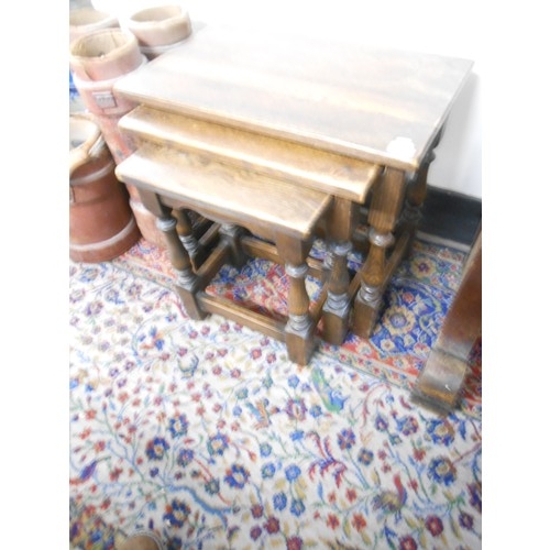 74 - A nest of three oak occasional tables with rectangular tops, on baluster turned legs united by strai... 