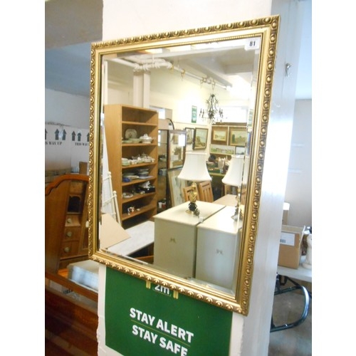 81 - A rectangular bevelled wall mirror in a gilt frame - 26in. x 10in.