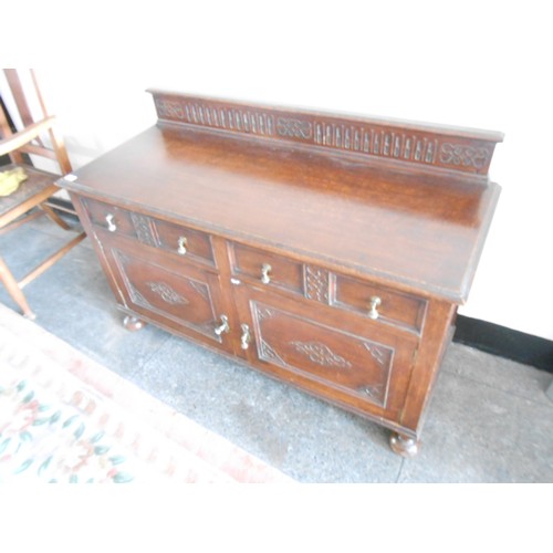 126 - An oak side cabinet with low raised back, fitted two drawers, cupboards under with brass drop handle... 