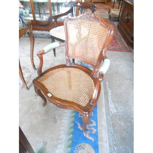 134 - A Victorian French walnut framed armchair with flower carved cresting rail, cane seat and back, on s... 