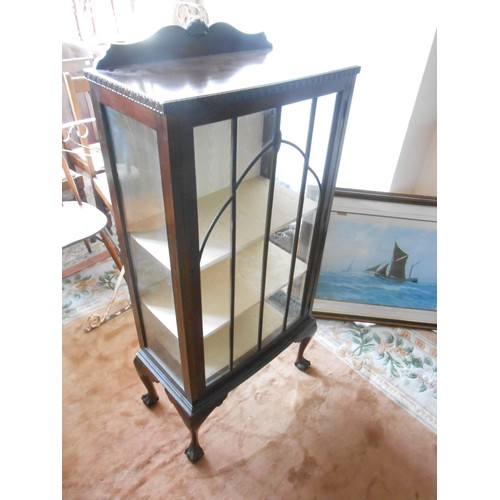 136 - A 1930's mahogany display cabinet with low raised back, fitted glass door and sides, on short cabrio... 