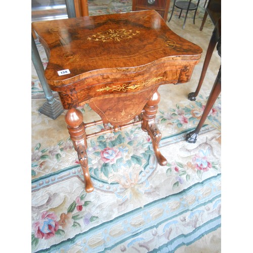 138 - A Victorian walnut and satinwood inlaid games/sewing table with shaped hinged lid enclosing chess an... 