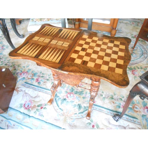 138 - A Victorian walnut and satinwood inlaid games/sewing table with shaped hinged lid enclosing chess an... 