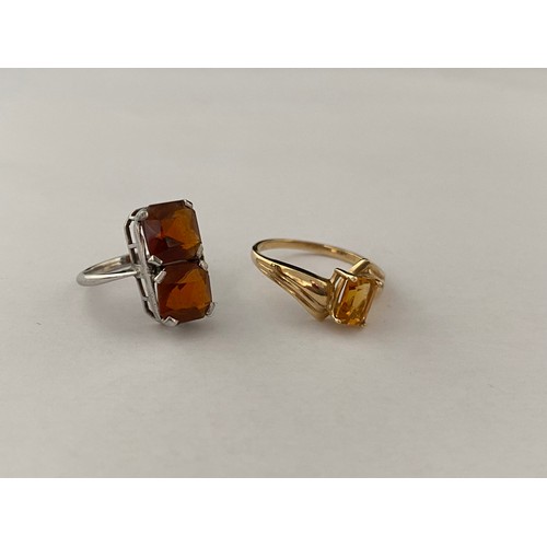 193 - A lady's ring set two orange coloured stones, on a white metal shank and one other lady's ring set o... 