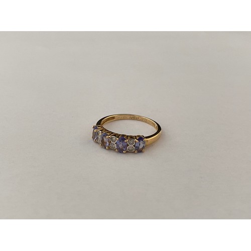 195 - A lady's ring set four tanzanites with diamond spacers, on a 14kt. gold shank