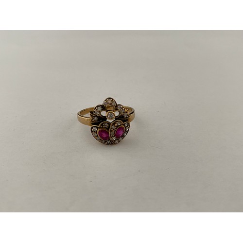 198 - A lady's ring in the form of two hearts and ribbon tie set two rubies and diamonds, on a 9ct. gold s... 