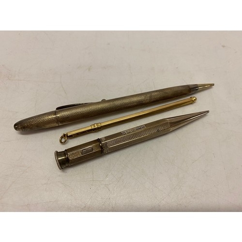 185 - Two propelling pencils in engine turned silver cases and a 9ct. gold swizzle stick