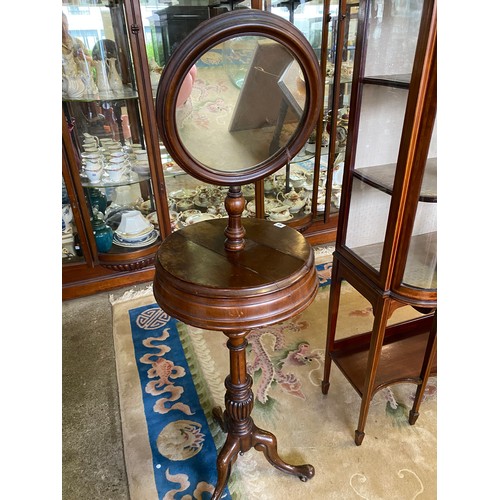 63 - A Victorian mahogany shaving stand with circular mirror, revolving hinged circular compartments, on ... 