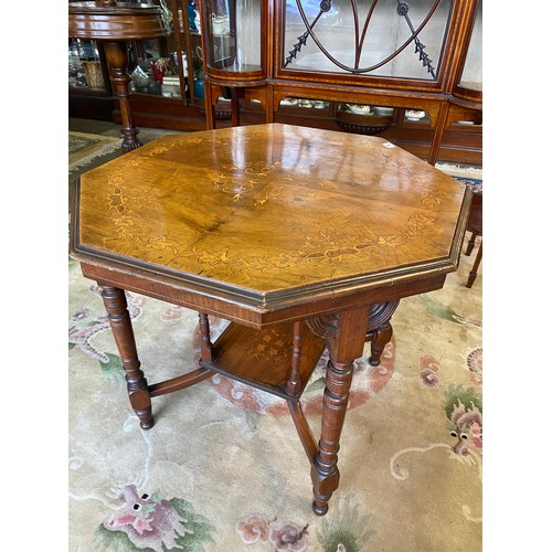 78 - An Edwardian walnut table, the octagonal top with inlaid decoration, on ring turned legs united by '... 