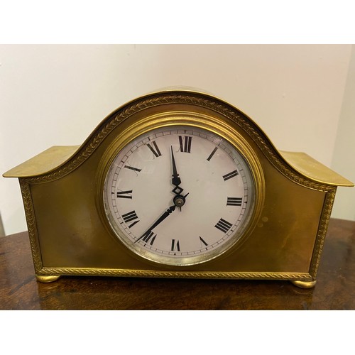 115 - A mantel clock with white enamel dial, in a swept brass case, on four pill feet - 5in. high