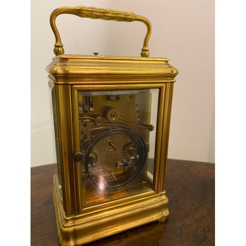 116 - A carriage clock by J.W Benson with white enamel dial, striking movement on a gong, in a brass and b... 