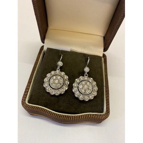 271 - A pair of Art Deco design diamond set flower form pendant drop earrings mounted in 18ct. white gold