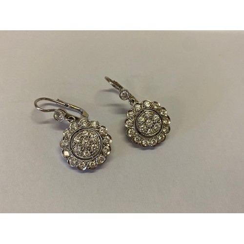 271 - A pair of Art Deco design diamond set flower form pendant drop earrings mounted in 18ct. white gold