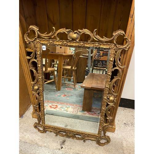 47 - A rectangular bevelled wall mirror in a gilt leaf scroll frame - 38in. x 28in.