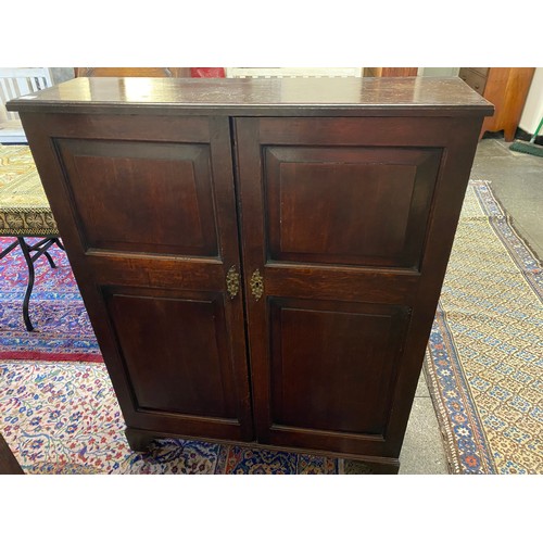 31 - A 19th Century oak cupboard fitted two panelled doors enclosing shelves, on bracket feet - 38 1/2in.... 