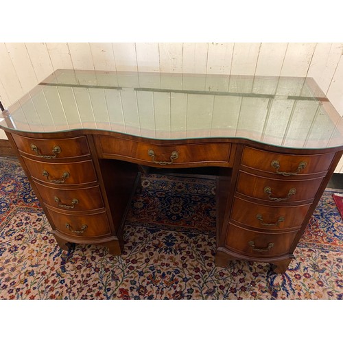 51 - A reproduction mahogany desk with green and gilt tooled leather top, fitted centre drawer and four d... 