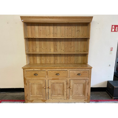 43 - A stripped pine dresser, the raised back fitted two shelves, the base fitted three drawers, cupboard... 