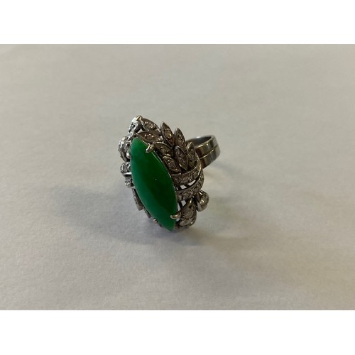 313 - A lady's ring set centre green stone surrounded by diamonds to leaf design, on a Chinese white metal... 