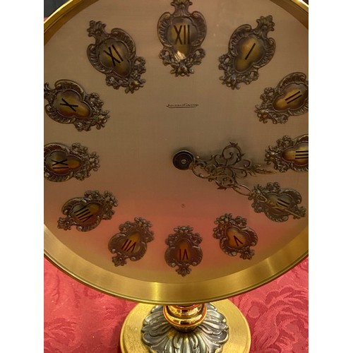 358 - A Jaeger Le Coultre mantel clock with ornate numerals, in a circular brass case, on circular base - ... 