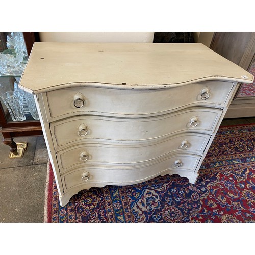 29 - A white painted chest with serpentine front, fitted four drawers, ring handles, on bracket feet - 42... 