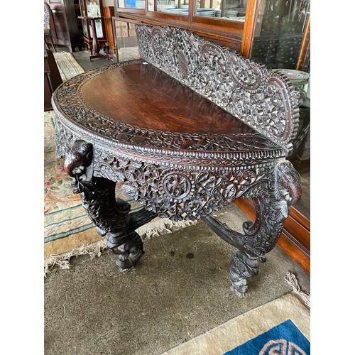 74 - An Indian padouk wood sidetable with half round top, carved and pierced to birds, flowers and leaves... 