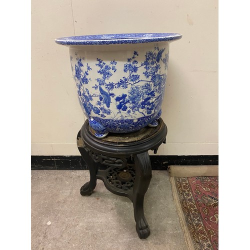 123 - A large Japanese blue and white jardiniere decorated flowers and birds, on three feet - 17in. high a... 