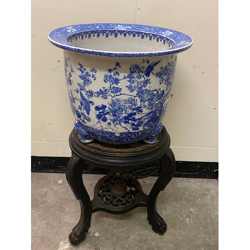 123 - A large Japanese blue and white jardiniere decorated flowers and birds, on three feet - 17in. high a... 