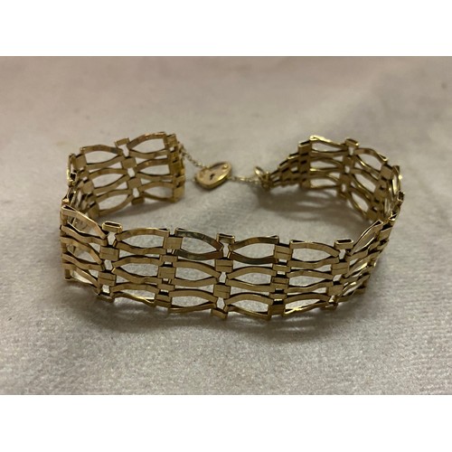 215 - A 9ct. gold gatelink bracelet with heart shaped padlock