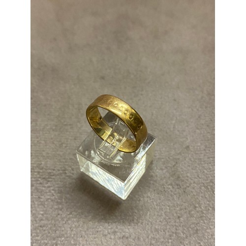 219 - A 9ct. gold wedding band with punched decoration