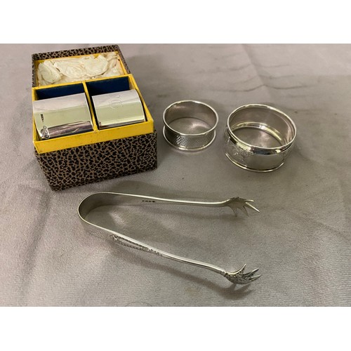 174 - Two silver napkin rings in fitted box, two other silver napkin rings and a pair of silver sugar tong... 