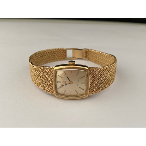 226 - A lady's Omega wristwatch in a 9ct. gold case, on a 9ct. gold woven integral bracelet