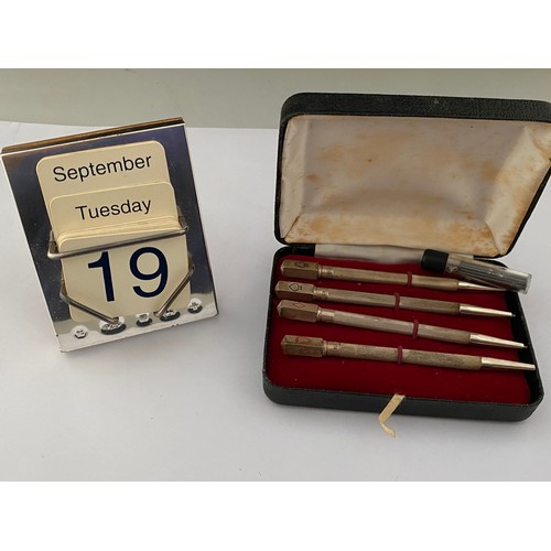 207 - A set of four bridge pencils in engine turned silver cases and a modern silver fronted desk calendar