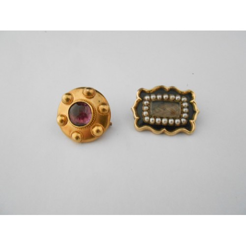 245 - A circular gold coloured metal brooch, the centre set cabochon amethyst coloured stone and a 19th Ce... 