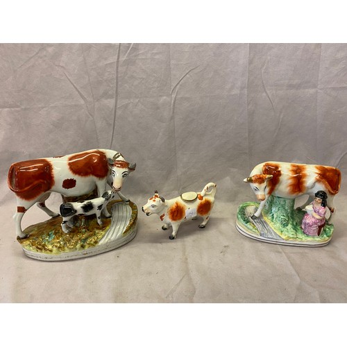 141 - Two large Staffordshire flatbacks as a cow and calf - 6in. high and cow with milk maid together with... 