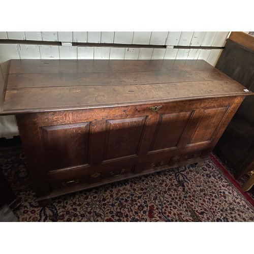 24 - An antique oak dower chest with hinged lid enclosing candlebox, four panels to the front, the base f... 