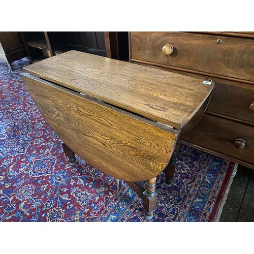 76 - A reproduction oak gateleg table fitted two rounded drop leaves, on turned and block legs - 36in. wi... 