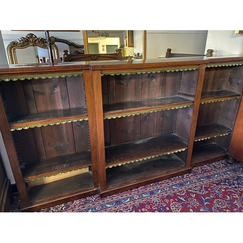 54 - A 19th Century mahogany breakfront openfront bookcase fitted shelves with green and gilt tooled leat... 