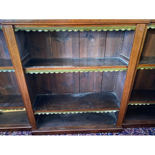 54 - A 19th Century mahogany breakfront openfront bookcase fitted shelves with green and gilt tooled leat... 