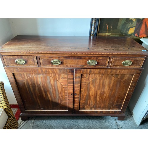 25 - A Georgian mahogany and crossbanded side cabinet fitted two frieze drawers, panelled doors under, on... 