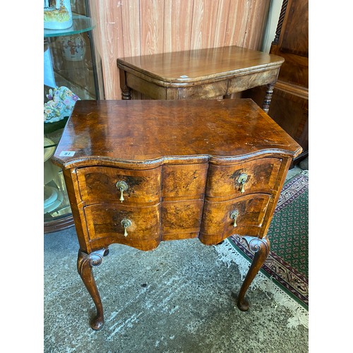 87 - A walnut veneered chest with serpentine front, fitted two drawers, on cabriole legs - 24in. wide