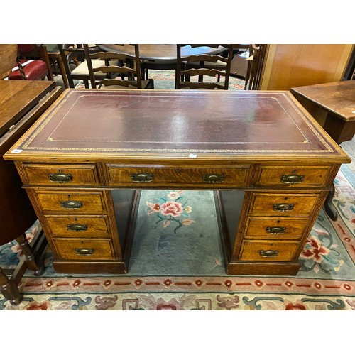 70 - An Edwardian oak desk with burgundy and gilt tooled leather top, three frieze drawers and three draw... 