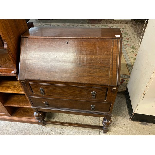 68 - An oak bureau with hinged fall front enclosing fitted interior above two drawers, on cup and cover l... 