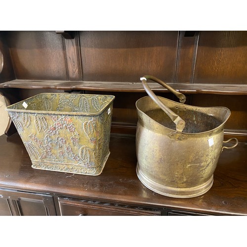 64 - A brass helmet shaped coal bucket with swing handle and a rectangular metal trough with raised decor... 