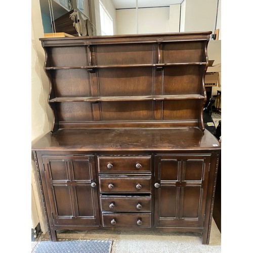 66 - An Ercol dark oak dining room suite comprising:- dining table fitted two rounded drop flaps, on pane... 