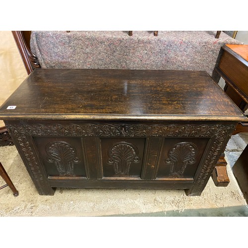 65 - An antique oak coffer with hinged lid, carved panelled front - 41in. wide