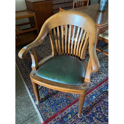 71 - A mahogany desk chair with curved comb shaped back, upholstered seat, on cylindrical legs terminatin... 