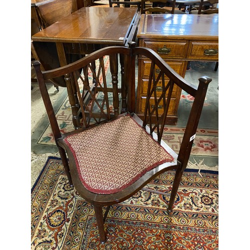 81 - An Edwardian mahogany corner reading chair with pierced 'X' shaped splats