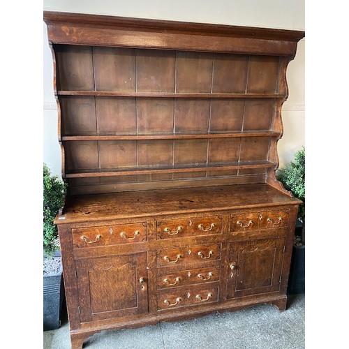 32 - A George III style oak dresser, the raised back fitted three shelves, the base fitted drawers and pa... 