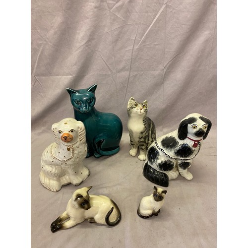 106 - A Winstanley model of a grey cat, two Beswick models of Siamese cats, a Poole Pottery turquoise glaz... 