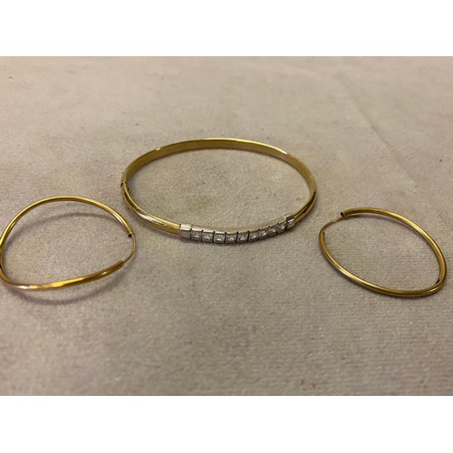 246 - A 9ct. two colour gold hinged bangle, the top set white stones and a pair of gold coloured metal hoo... 